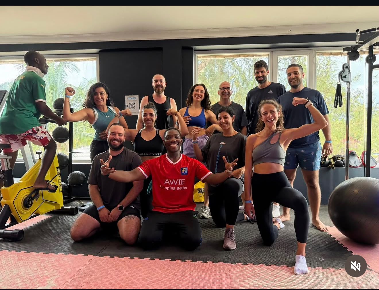 A full group of members gathered on the gym floor at the end of a class in Kendwa